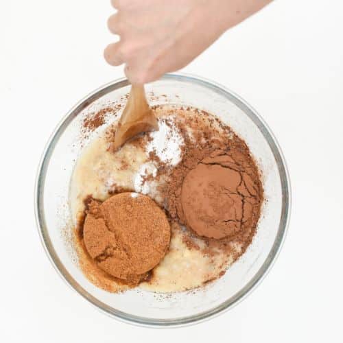 Mixing Vegan Chocolate Banana Muffin batter ingredients in a mixing bowl.