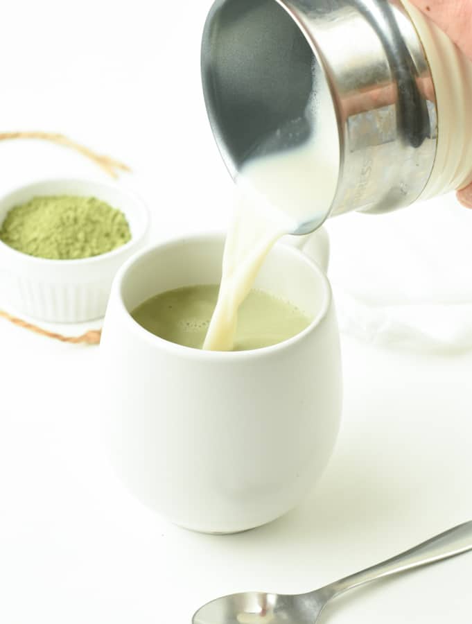 Pouring healthy Matcha Latte into a mug.