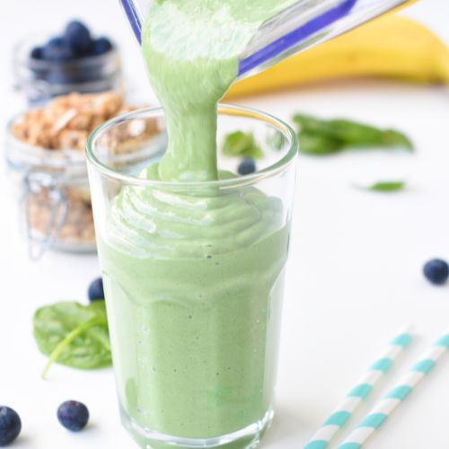 Pouring spirulina smoothie from a blender.