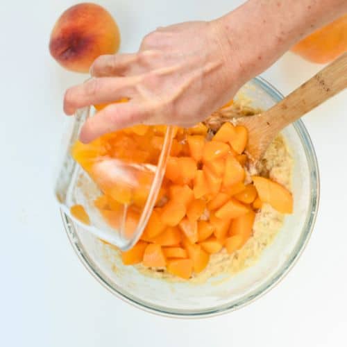 Adding peaches to the Vegan Peach Muffins ingredients.