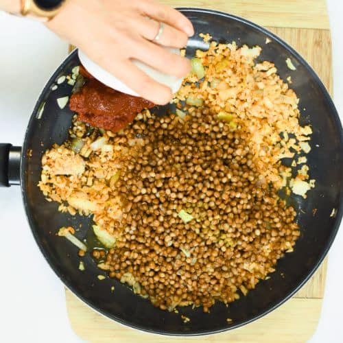 Adding lentils to the Lentil Taco Meat ingredients.