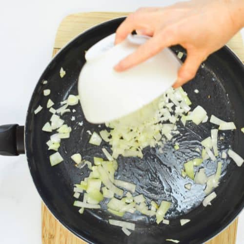 Pouring onions in the pan for the Lentil Taco Meat