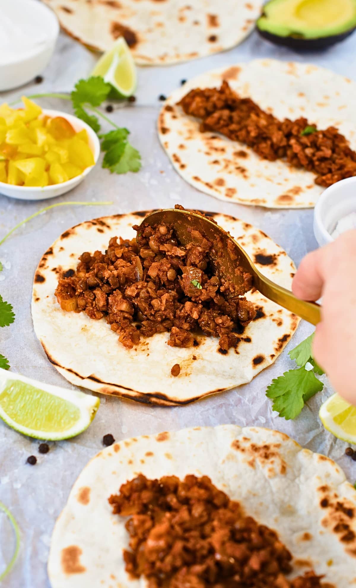 Pouring Lentil Taco Meat on a tortilla