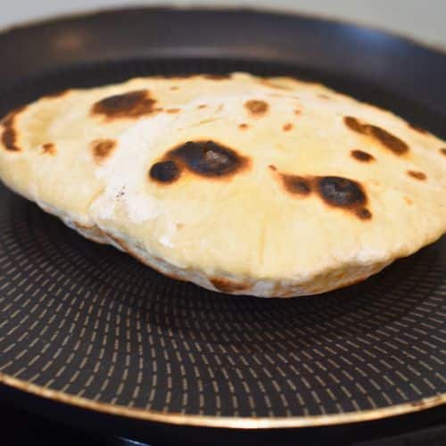 Vegan Naan Bread cooking on a crepe pan.