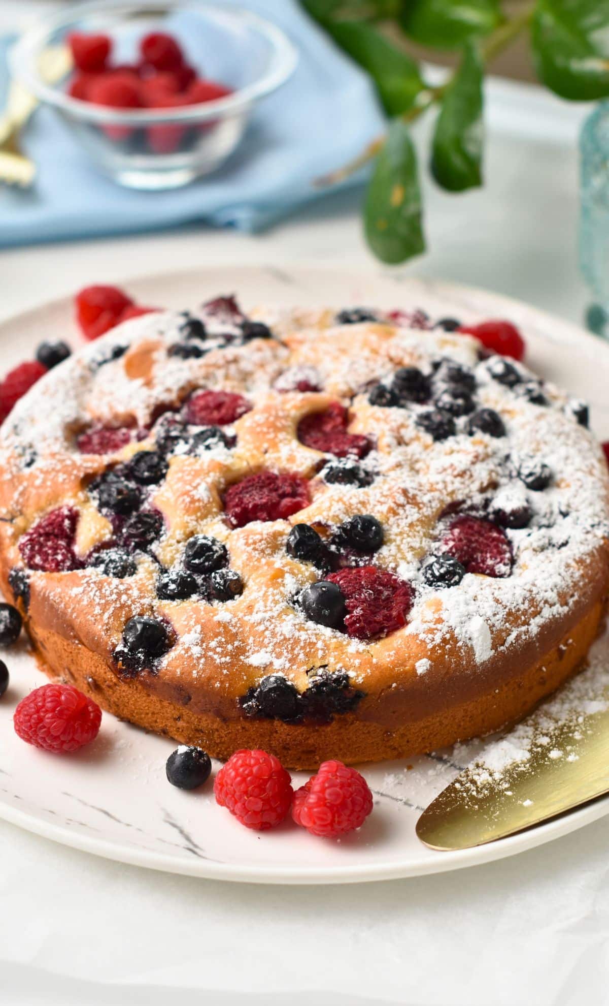 Yogurt Berry Cake decorated with fresh berries on a plate.