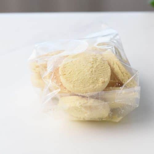 Placing shortbread cookies in a plastic bag.