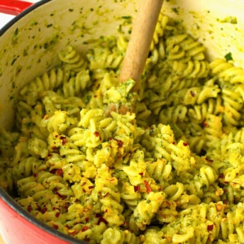 Green Pasta Sauce in a pan with a wooden spoon.