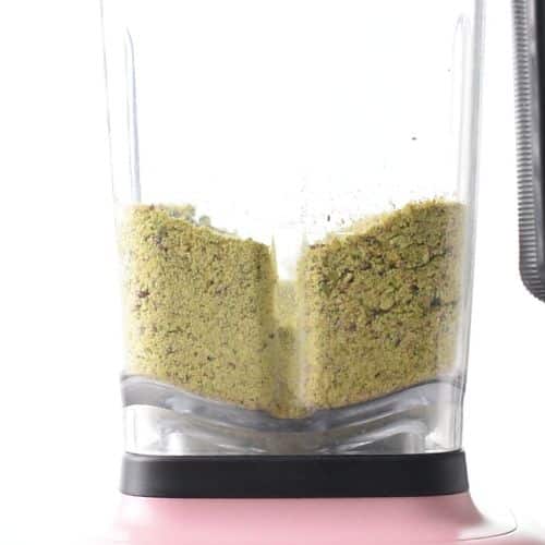 Blended pistachio in the jug of a blender.