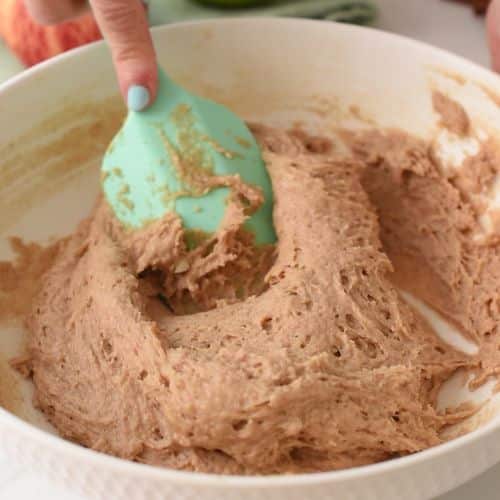 Stirring the applesauce cake batter with a silicone spatula.