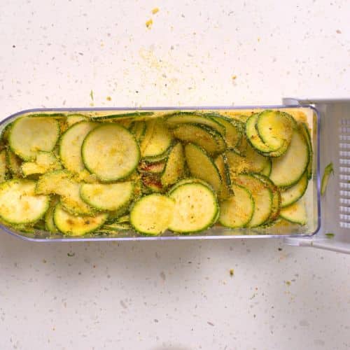 Sliced zucchini in a slicer.