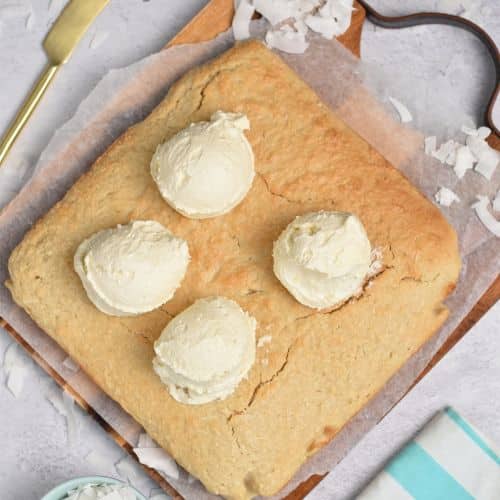 Adding frosting dollops on the Easy Coconut Cake