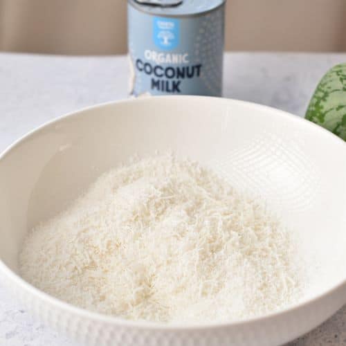 Shredded Coconut and coconut cream in a mixing bowl.