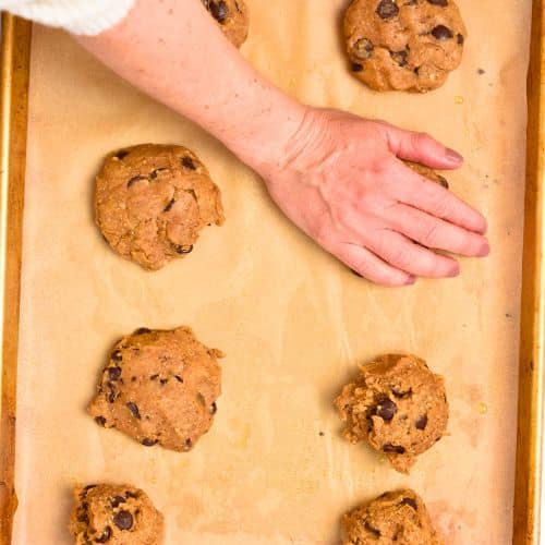 Flattening Lentil Cookie on a cookie sheet.