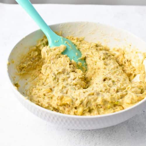 Pistachio Banana Bread batter in a bowl with a silicone spatula.