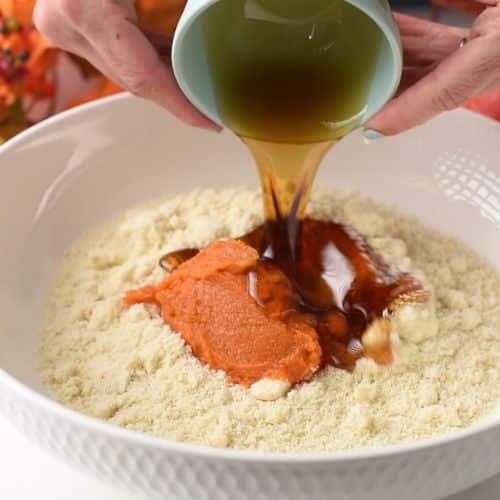 Pouring the ingredients for Pumpkin Bites into a bowl.