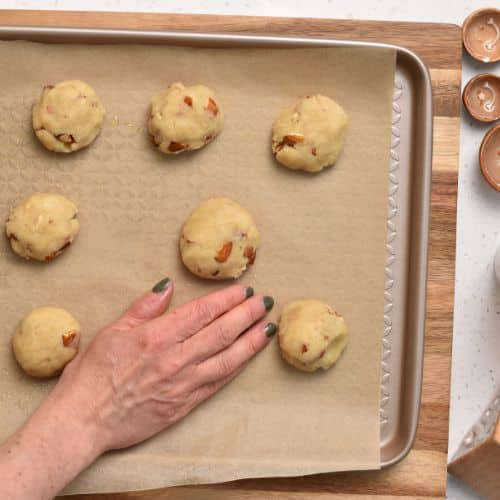 Forming Almond Snowball Cookies on a baking sheet.