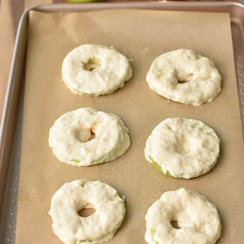 Apple Rings ready to bake on a baking sheet.