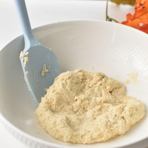 Baked Apple Donuts dough in a mixing bowl with a silicone spatula.