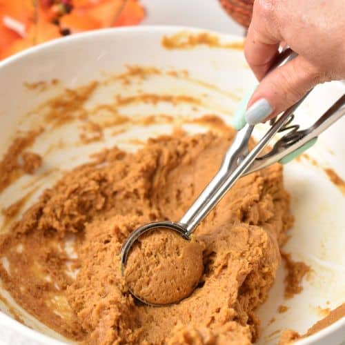 Scooping Easy Pumpkin Cookie dough with a cookie scoop.