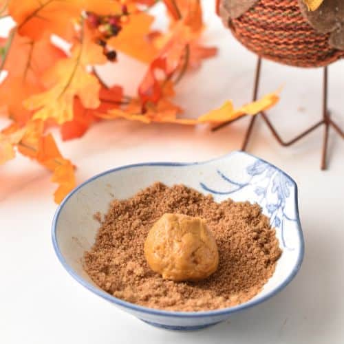 Rolling Easy Pumpkin Cookie dough balls in cinnamon sugar.