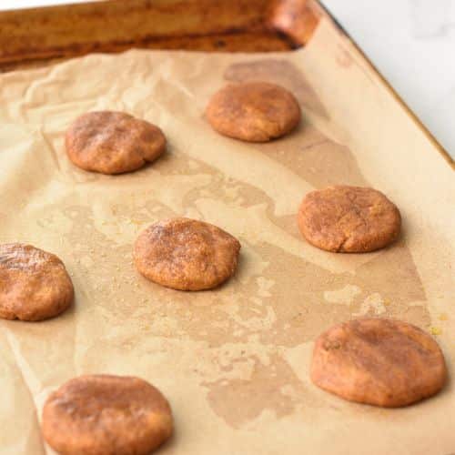 Flattened Easy Pumpkin Cookies on a baking sheet.