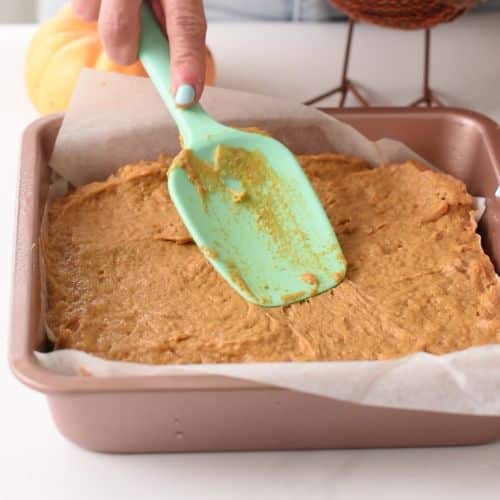 Flattening Pumpkin Banana Cake batter in a square pan.