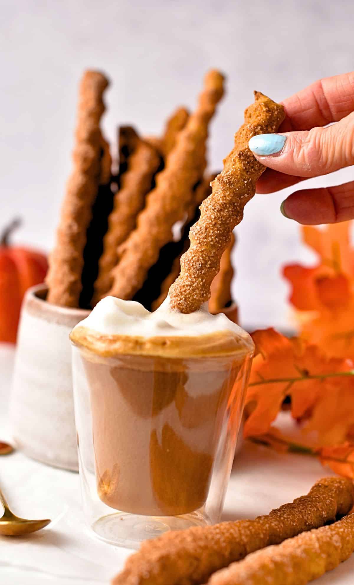 Digging a Pumpkin Stick Cookies into a latte.