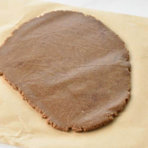 Almond Flour Gingerbread Cookie dough flattened on a baking sheet.