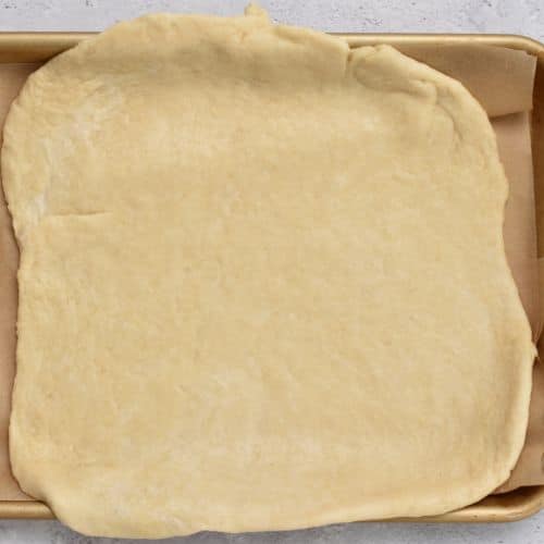 Galette dough rolled on a baking sheet.