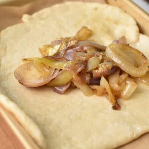 Cooked onion on galette dough.