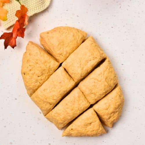 Slicing the Pumpkin Bread Roll dough into 8 pieces.