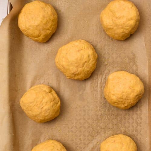 Rolled Pumpkin Bread Rolls on a baking sheet.