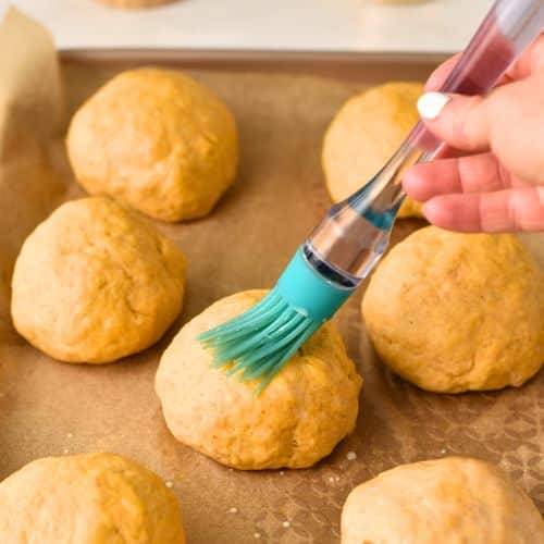 Brushing Pumpkin Bread Roll with almond milk.