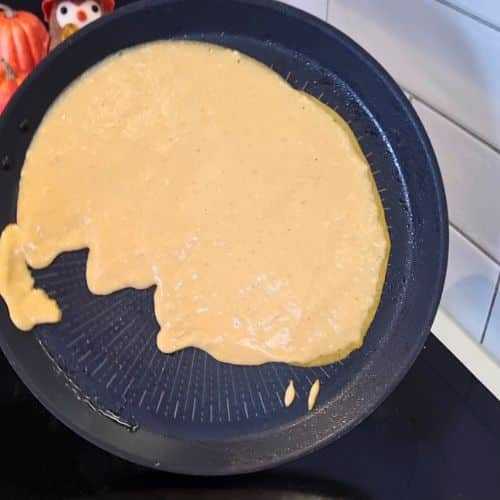 Spreading Pumpkin Crepes batter in a crepe pan.