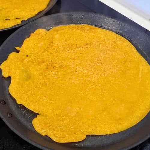 Pumpkin Crepes cooking on a crepe pan.