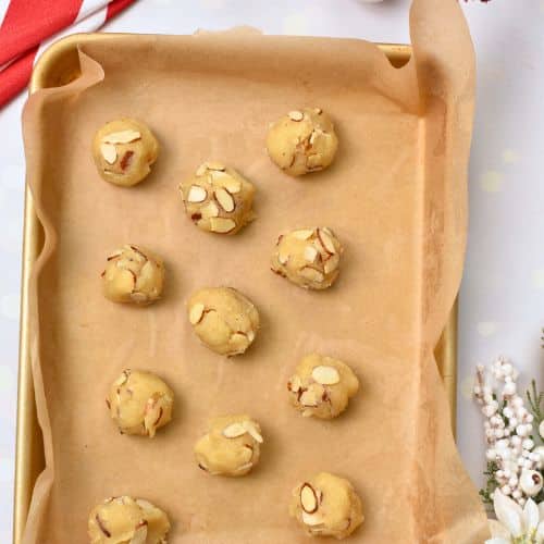 Almond Christmas Cookie dough balls on a baking sheet.