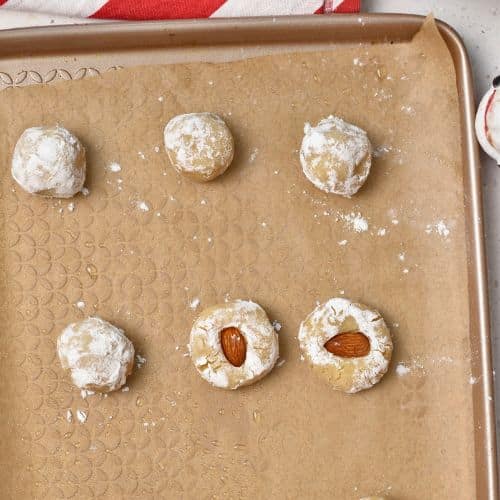 Almond Cookies with an almond on a baking sheet.