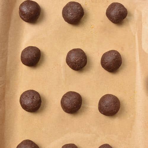 Chocolate Almond Thumbprint Cookie dough balls on a baking sheet.