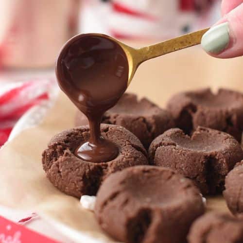 Pouring the chocolate filling into the cooked Chocolate Almond Thumbprint Cookies