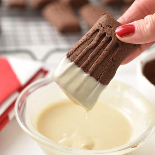 Dipping Chocolate Shortbread Cookies into melted white chocolate.