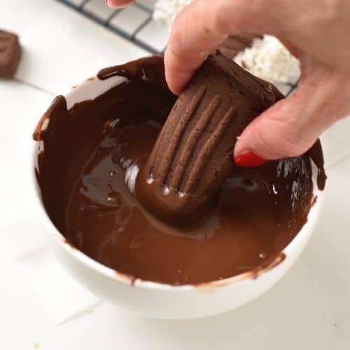 Dipping an end of a Chocolate Shortbread Cookie into melted chocolate.