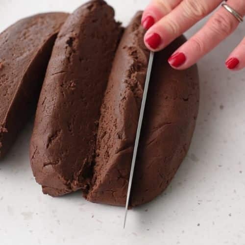 Cutting logs of Chocolate Thumbprint Cookie dough.