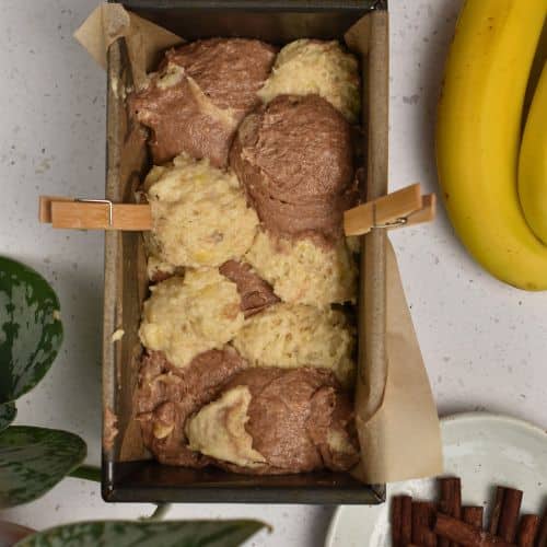 Loaf pan filled with the two Cinnamon Banana Bread batters.