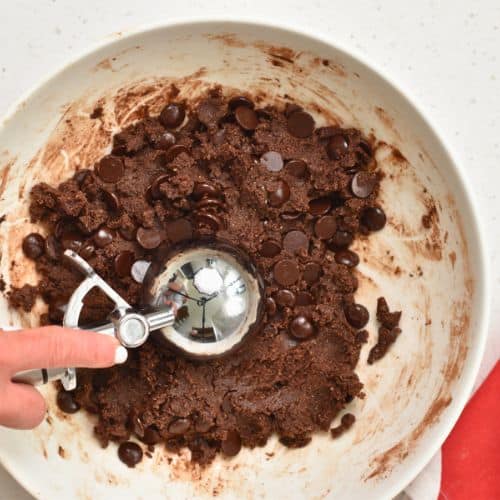 Scooping Healthy Chocolate Cookie dough with an ice cream scoop.