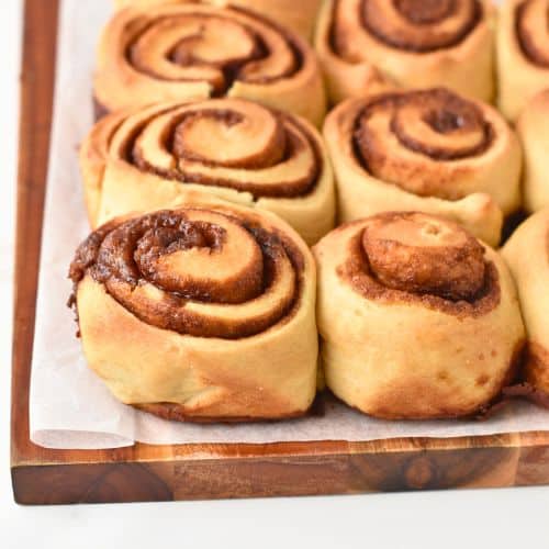 Cooked Healthy Cinnamon Rolls on a chopping board ready to be frosted.