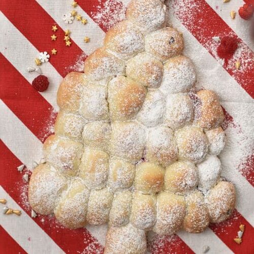 Adding powdered sugar to the Pull Apart Christmas Tree Bread.