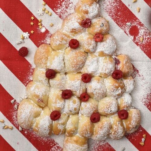 Pull Apart Christmas Tree Bread decorated with powdered sugar and fresh raspberries.