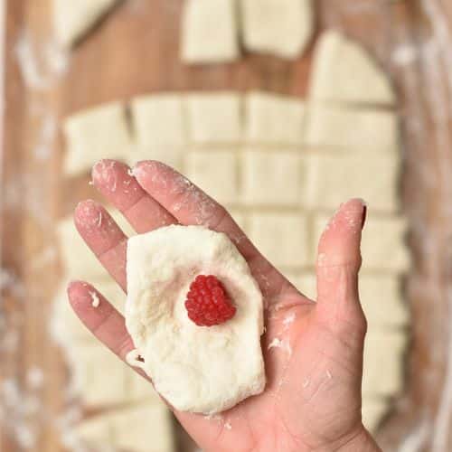 Square of Pull Apart Christmas Tree Bread dough with a fresh raspberries.