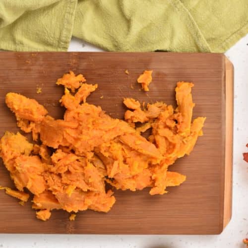 Cooked sweet potato flesh on a chopping board.