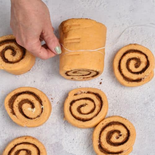 Cutting Sweet Potato Cinnamon Rolls with dental floss.